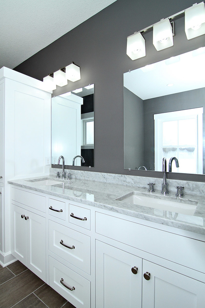 Inredning av ett lantligt mellanstort badrum, med ett undermonterad handfat, vita skåp, granitbänkskiva, ett fristående badkar, en öppen dusch, en toalettstol med separat cisternkåpa, grå kakel, keramikplattor, grå väggar, klinkergolv i keramik och skåp i shakerstil