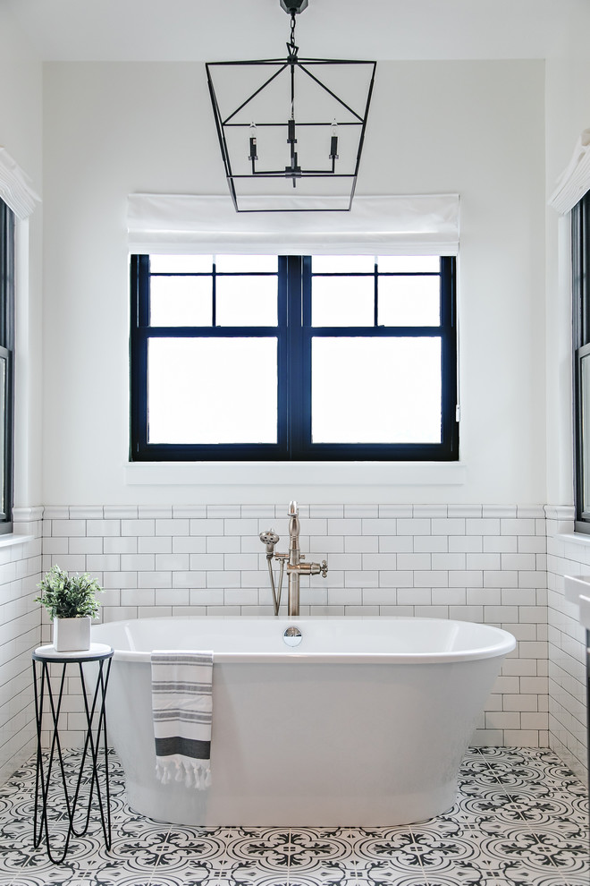 Пример оригинального дизайна: главная ванная комната в стиле кантри с отдельно стоящей ванной, белой плиткой, плиткой кабанчик, белыми стенами и разноцветным полом