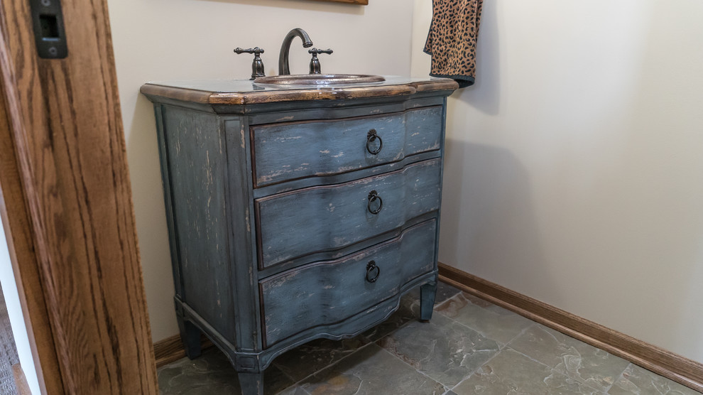 Foto på ett litet lantligt badrum, med skåp i slitet trä, beige väggar, skiffergolv och flerfärgat golv