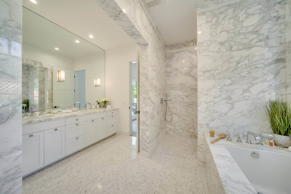 Idée de décoration pour une salle de bain design avec un placard à porte shaker, des portes de placard blanches, une baignoire encastrée, une douche ouverte, un mur blanc, un lavabo encastré, un sol blanc et un plan de toilette blanc.