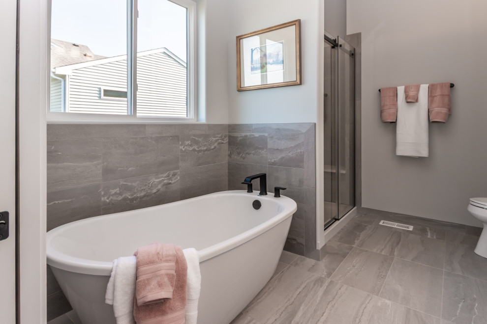 Example of a mid-sized cottage master gray tile and porcelain tile porcelain tile and gray floor bathroom design in Chicago with shaker cabinets, white cabinets, a two-piece toilet, gray walls, an undermount sink, quartz countertops and white countertops