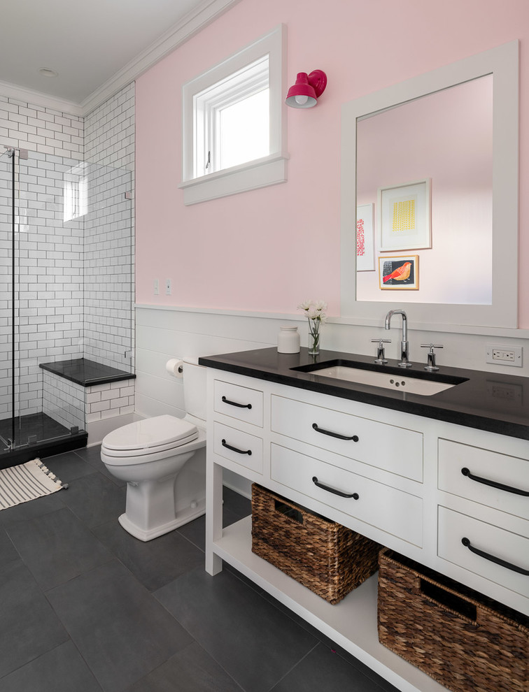 ニューヨークにある高級な広いカントリー風のおしゃれな浴室 (フラットパネル扉のキャビネット、白いキャビネット、置き型浴槽、分離型トイレ、サブウェイタイル、スレートの床、アンダーカウンター洗面器、グレーの床、黒い洗面カウンター、コーナー設置型シャワー、白いタイル、ピンクの壁、開き戸のシャワー) の写真