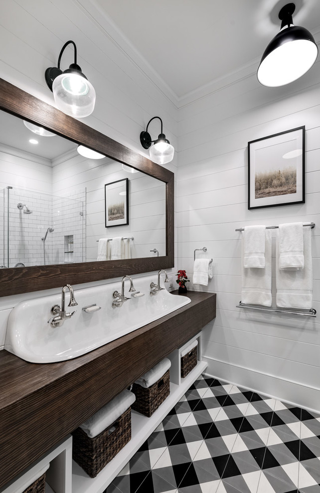 ニューヨークにある高級な広いカントリー風のおしゃれなバスルーム (浴槽なし) (オープンシェルフ、濃色木目調キャビネット、コーナー型浴槽、オープン型シャワー、白いタイル、サブウェイタイル、白い壁、セラミックタイルの床、オーバーカウンターシンク、木製洗面台、茶色い床、オープンシャワー、ブラウンの洗面カウンター) の写真
