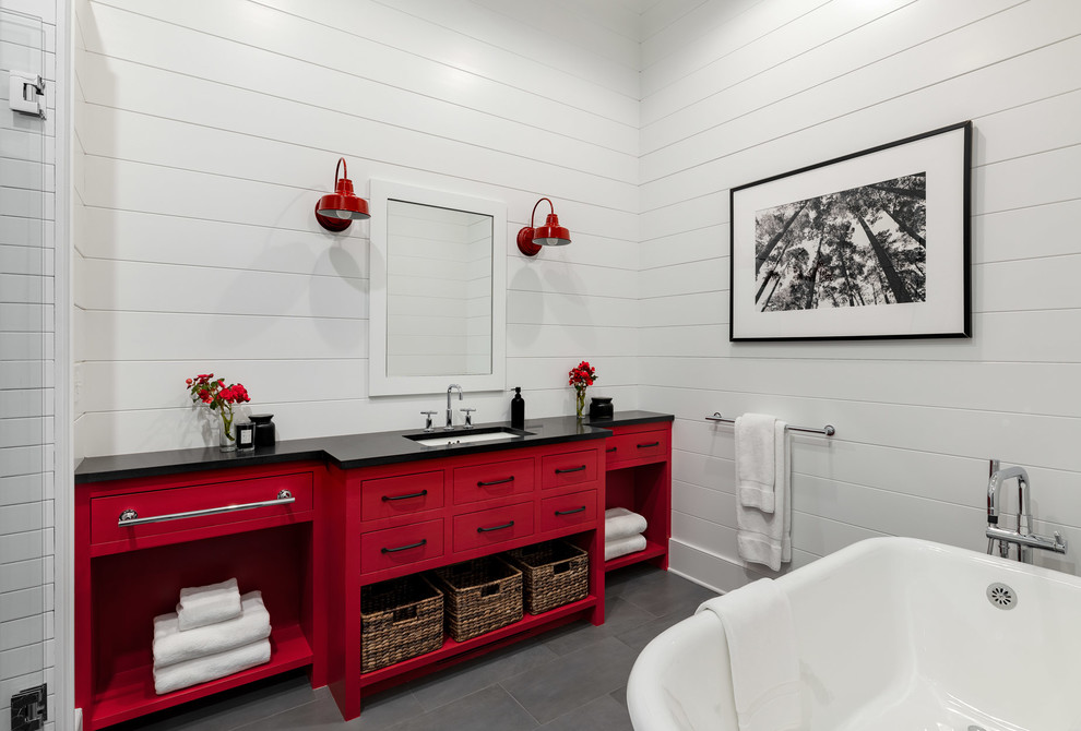ニューヨークにある高級な広いカントリー風のおしゃれな浴室 (フラットパネル扉のキャビネット、赤いキャビネット、置き型浴槽、白いタイル、白い壁、スレートの床、アンダーカウンター洗面器、コンクリートの洗面台、グレーの床、黒い洗面カウンター) の写真