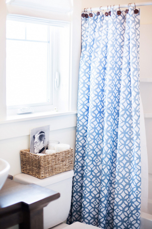 Foto de cuarto de baño de estilo de casa de campo de tamaño medio con armarios con paneles lisos, bañera esquinera, combinación de ducha y bañera, sanitario de una pieza, paredes blancas, suelo con mosaicos de baldosas, aseo y ducha, lavabo sobreencimera y encimera de madera