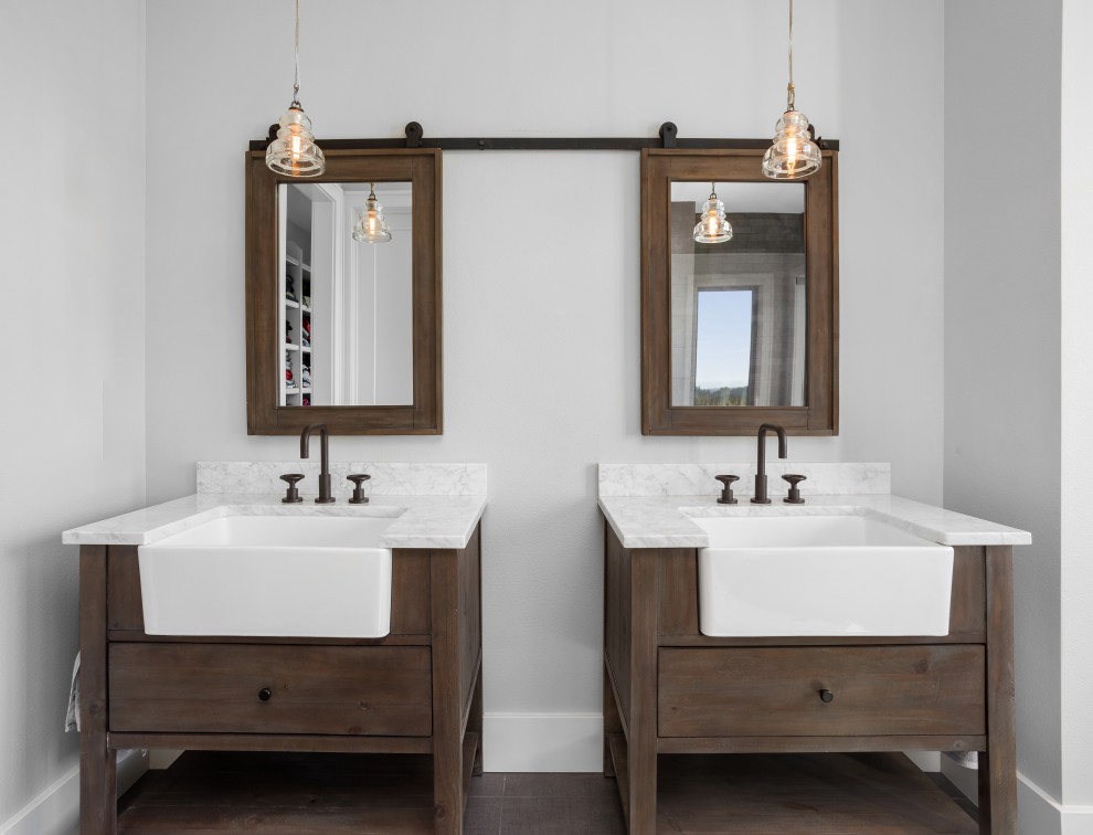 Réalisation d'une salle de bain principale champêtre en bois brun avec un placard à porte plane, un mur gris, un lavabo encastré, un plan de toilette en marbre, un sol marron et un plan de toilette gris.