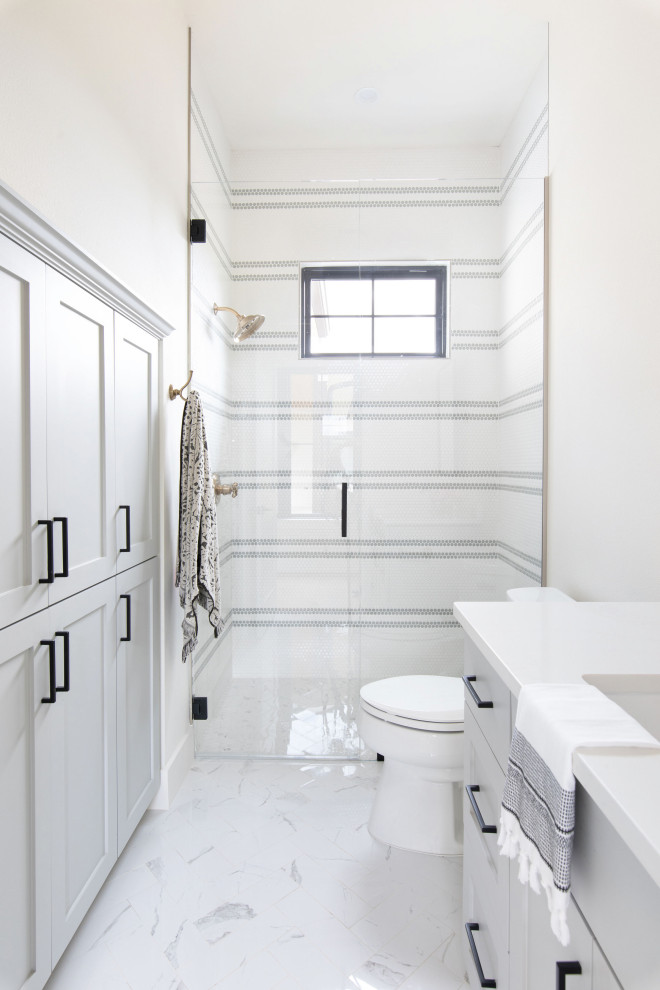 Идея дизайна: ванная комната в стиле кантри с фасадами с утопленной филенкой, серыми фасадами, душем в нише, белой плиткой, плиткой мозаикой, белыми стенами, врезной раковиной, белым полом, душем с распашными дверями и белой столешницей