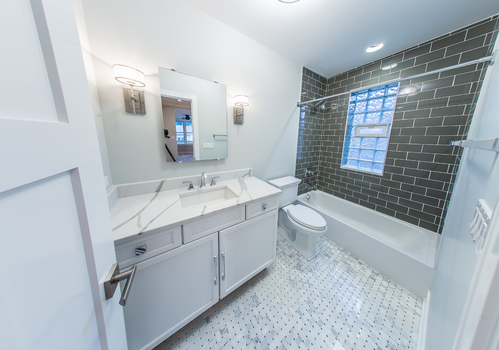 Стильный дизайн: ванная комната среднего размера в стиле модернизм с фасадами с утопленной филенкой, белыми фасадами, ванной в нише, душем над ванной, унитазом-моноблоком, серой плиткой, стеклянной плиткой, белыми стенами, мраморным полом, душевой кабиной, врезной раковиной, мраморной столешницей, белым полом, шторкой для ванной, белой столешницей, тумбой под одну раковину и напольной тумбой - последний тренд