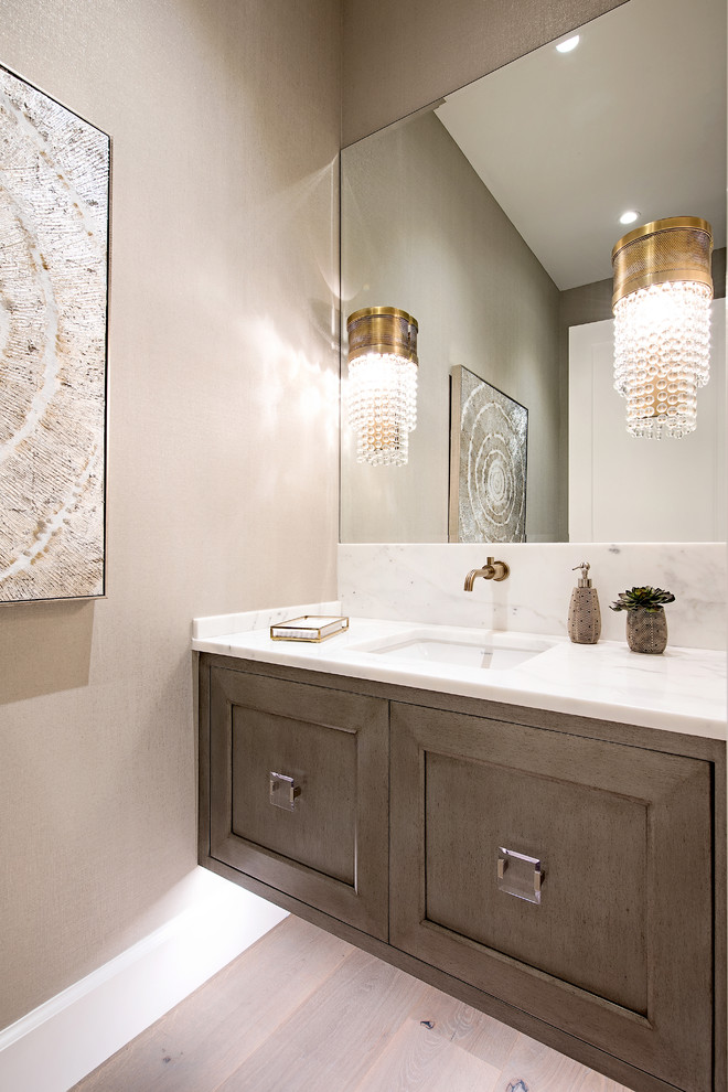 Example of a small transitional gray tile light wood floor and beige floor bathroom design in Other with furniture-like cabinets, brown cabinets, beige walls, an undermount sink, marble countertops and white countertops