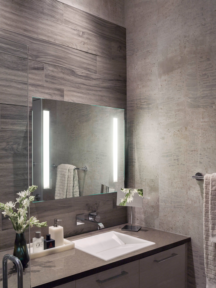 Photo of a medium sized contemporary ensuite wet room bathroom in San Francisco with flat-panel cabinets, a wall mounted toilet, grey tiles, ceramic tiles, grey walls, ceramic flooring, a trough sink, grey floors and a hinged door.