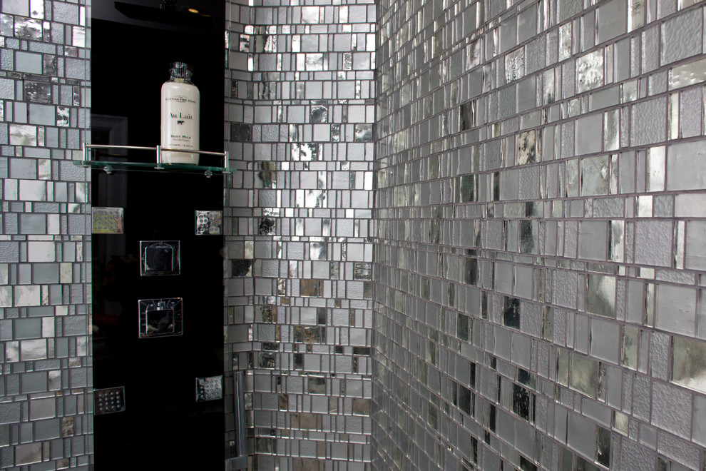 На фото: большая главная ванная комната в стиле модернизм с плоскими фасадами, серыми фасадами, душем без бортиков, раздельным унитазом, серой плиткой, стеклянной плиткой, серыми стенами, полом из травертина и монолитной раковиной с