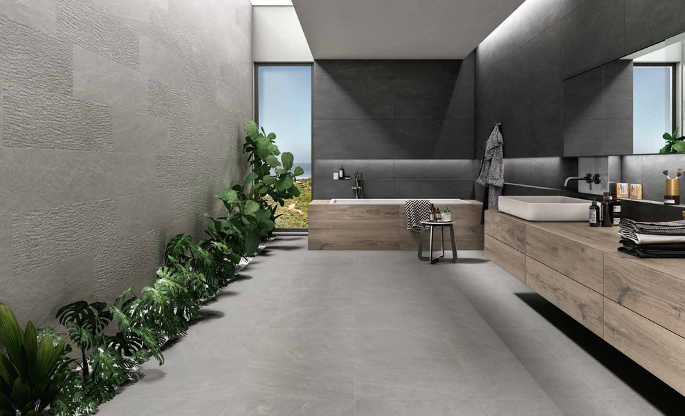 Drop-in bathtub - large modern master gray tile and porcelain tile porcelain tile and gray floor drop-in bathtub idea in Miami with flat-panel cabinets, medium tone wood cabinets, gray walls, wood countertops and a vessel sink