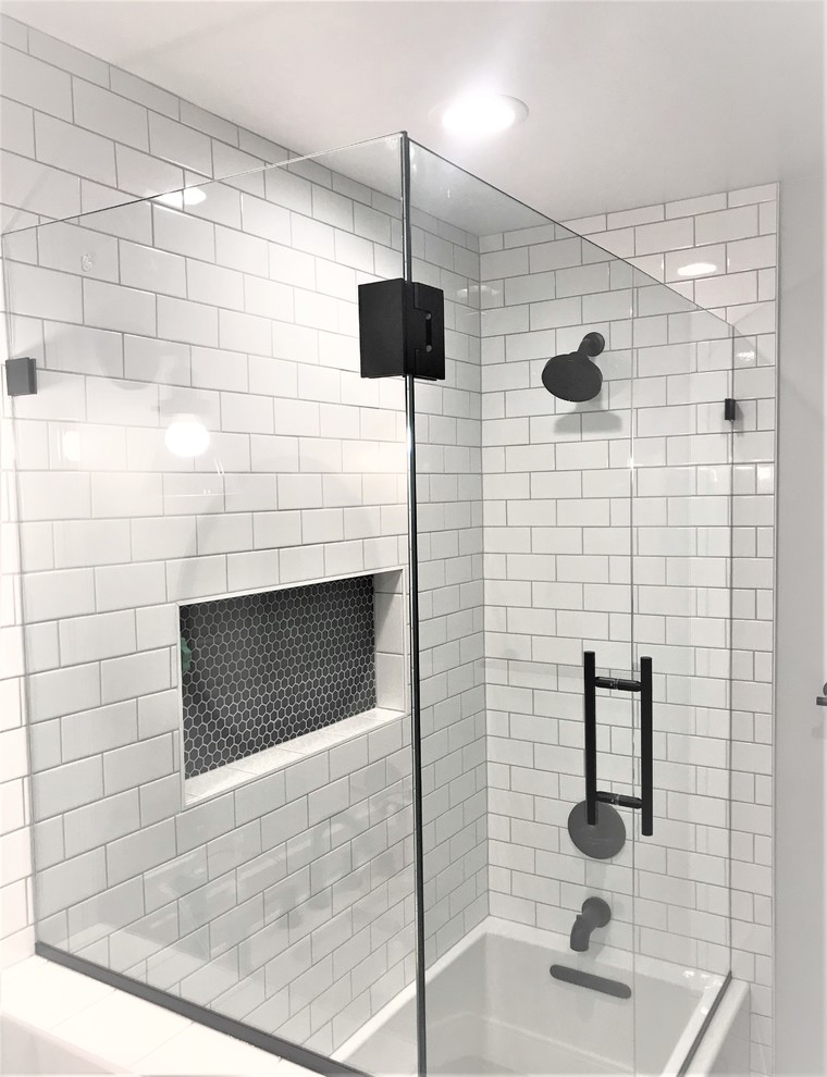 Свежая идея для дизайна: главная ванная комната среднего размера в стиле модернизм с белой плиткой, полом из керамической плитки, монолитной раковиной, столешницей из кварцита, черным полом, душем с распашными дверями, белой столешницей, фасадами с утопленной филенкой, светлыми деревянными фасадами, накладной ванной, душем над ванной, керамической плиткой и белыми стенами - отличное фото интерьера