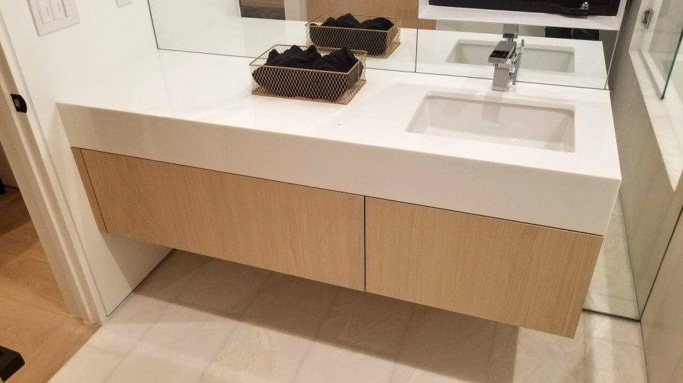Exempel på ett mellanstort modernt vit vitt en-suite badrum, med släta luckor, skåp i ljust trä, ett badkar i en alkov, en dusch/badkar-kombination, en vägghängd toalettstol, vit kakel, marmorkakel, vita väggar, marmorgolv, ett undermonterad handfat, bänkskiva i kvarts, brunt golv och dusch med gångjärnsdörr