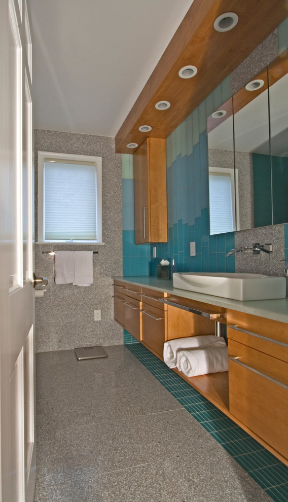 Esempio di una grande stanza da bagno con doccia minimalista con ante lisce, ante in legno chiaro, doccia ad angolo, piastrelle blu, piastrelle di vetro, pareti blu, pavimento in gres porcellanato, lavabo a bacinella e top in quarzo composito