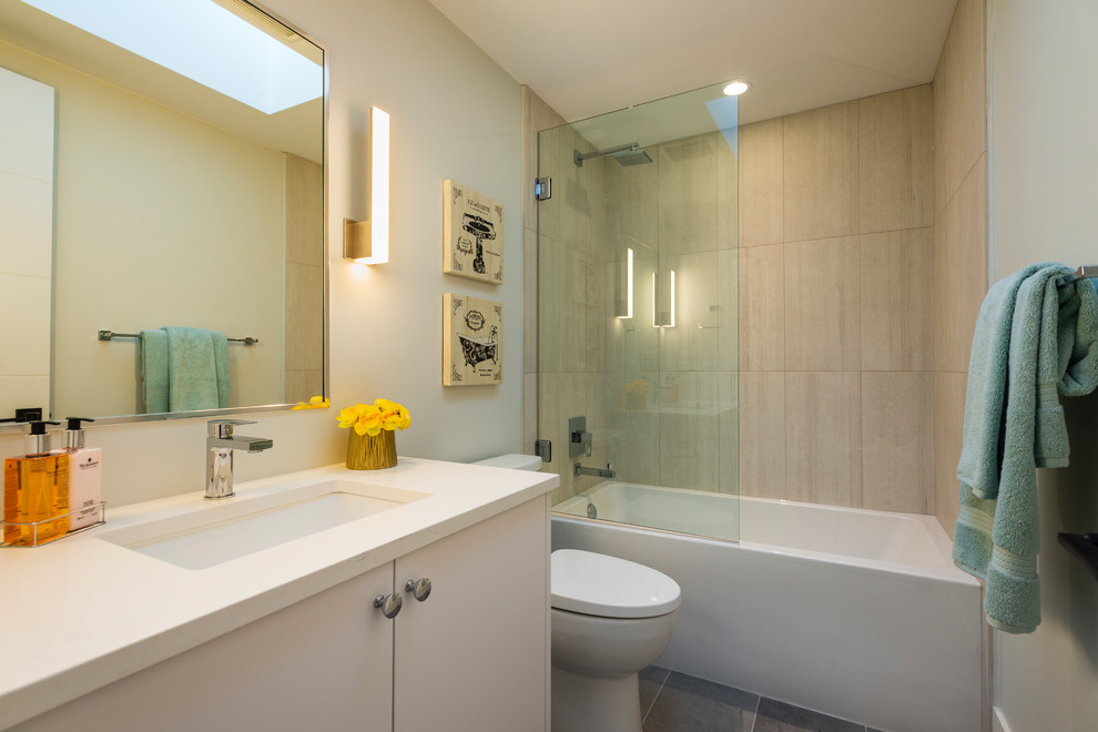 Bathroom - large contemporary 3/4 gray tile and porcelain tile porcelain tile and gray floor bathroom idea in Vancouver with flat-panel cabinets, white cabinets, a two-piece toilet, white walls, an undermount sink, quartz countertops and white countertops