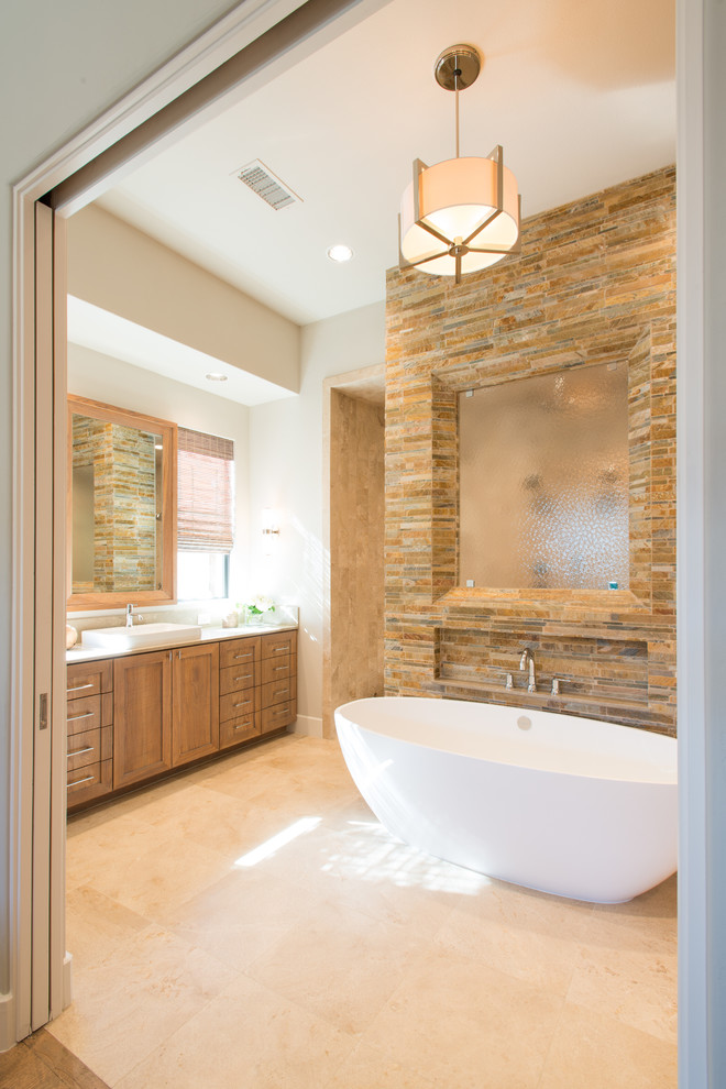 На фото: ванная комната в стиле неоклассика (современная классика) с настольной раковиной, фасадами в стиле шейкер, фасадами цвета дерева среднего тона, отдельно стоящей ванной, коричневой плиткой, каменной плиткой и белыми стенами