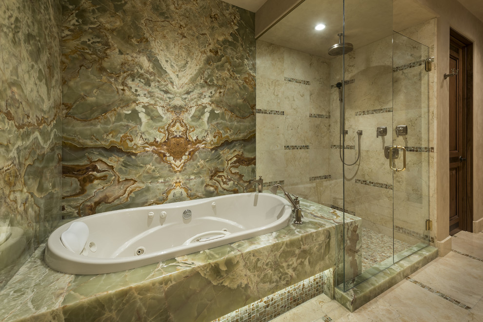 Exemple d'une grande salle de bain tendance en bois clair avec un placard en trompe-l'oeil, un carrelage beige, un carrelage de pierre, un mur beige, un sol en marbre, un lavabo encastré, un plan de toilette en granite et une baignoire encastrée.
