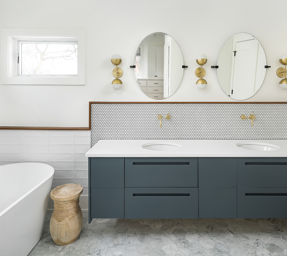 Cette photo montre une salle de bain principale tendance avec un placard à porte plane, une baignoire indépendante, un carrelage blanc, un sol en marbre, un lavabo encastré, un sol gris et un plan de toilette jaune.