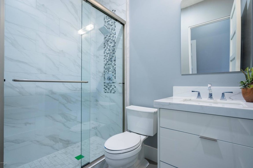 На фото: огромная главная ванная комната в стиле модернизм с плоскими фасадами, коричневыми фасадами, отдельно стоящей ванной, открытым душем, унитазом-моноблоком, белой плиткой, мраморной плиткой, белыми стенами, полом из керамогранита, настольной раковиной, мраморной столешницей, бежевым полом, открытым душем и белой столешницей с
