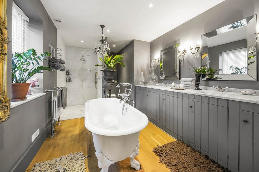 ロンドンにある中くらいなシャビーシック調のおしゃれな浴室 (インセット扉のキャビネット、グレーのキャビネット、猫足バスタブ、グレーの壁、大理石の洗面台、ベージュの床、グレーの洗面カウンター) の写真