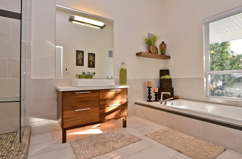 Idéer för att renovera ett stort funkis en-suite badrum, med ett fristående handfat, släta luckor, skåp i mellenmörkt trä, ett platsbyggt badkar, en öppen dusch, vit kakel, porslinskakel, vita väggar, klinkergolv i porslin, bänkskiva i kvarts och med dusch som är öppen