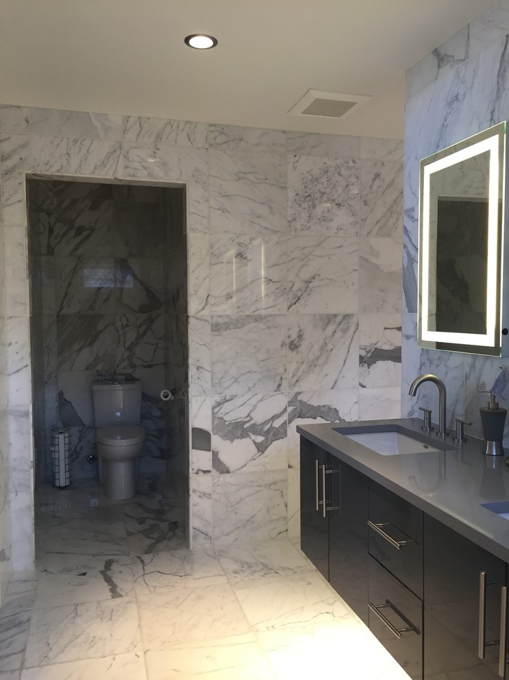 Idéer för att renovera ett stort funkis en-suite badrum, med släta luckor, svarta skåp, våtrum, en toalettstol med hel cisternkåpa, vit kakel, marmorkakel, vita väggar, marmorgolv, ett undermonterad handfat, bänkskiva i akrylsten, vitt golv och med dusch som är öppen