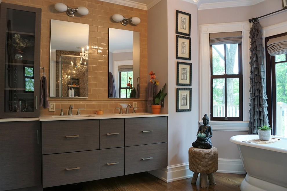 Modernes Badezimmer mit flächenbündigen Schrankfronten, grauen Schränken, freistehender Badewanne, braunen Fliesen, Metrofliesen, lila Wandfarbe, braunem Holzboden, Unterbauwaschbecken, braunem Boden und weißer Waschtischplatte in New York
