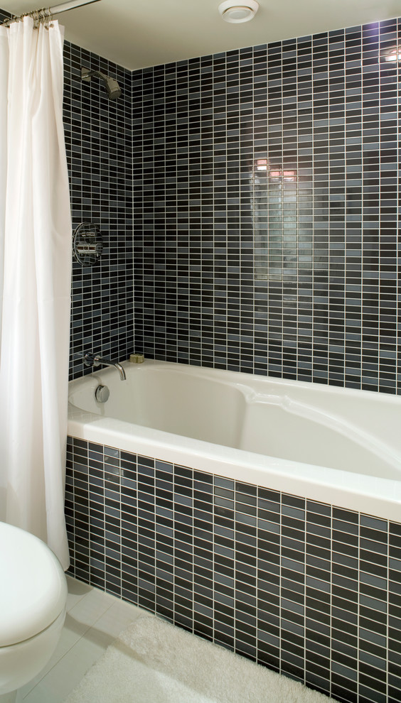Foto di una stanza da bagno moderna con vasca da incasso, vasca/doccia e piastrelle nere