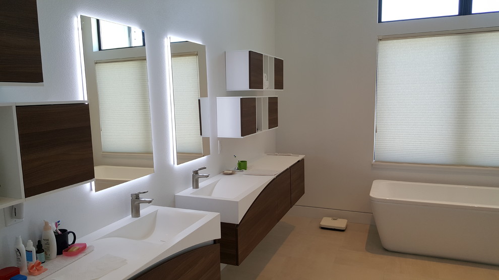 Idéer för ett stort modernt en-suite badrum, med släta luckor, skåp i mellenmörkt trä, ett fristående badkar, vita väggar, klinkergolv i porslin, ett integrerad handfat, bänkskiva i akrylsten och beiget golv