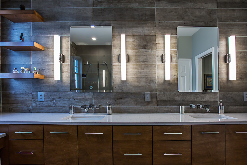 Example of a mid-sized trendy master gray tile and porcelain tile porcelain tile and gray floor corner shower design in Richmond with flat-panel cabinets, medium tone wood cabinets, gray walls, an undermount sink, quartz countertops, a one-piece toilet and a hinged shower door