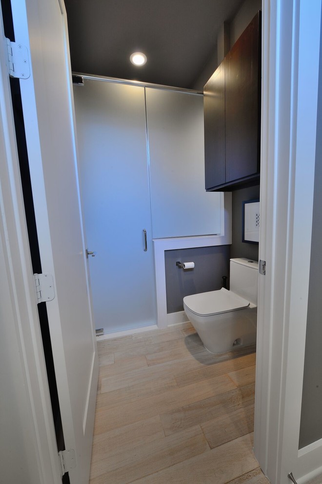 Foto di una stanza da bagno per bambini moderna di medie dimensioni con ante lisce, ante in legno bruno, doccia alcova, WC monopezzo, pareti verdi, pavimento in bambù e top in quarzo composito