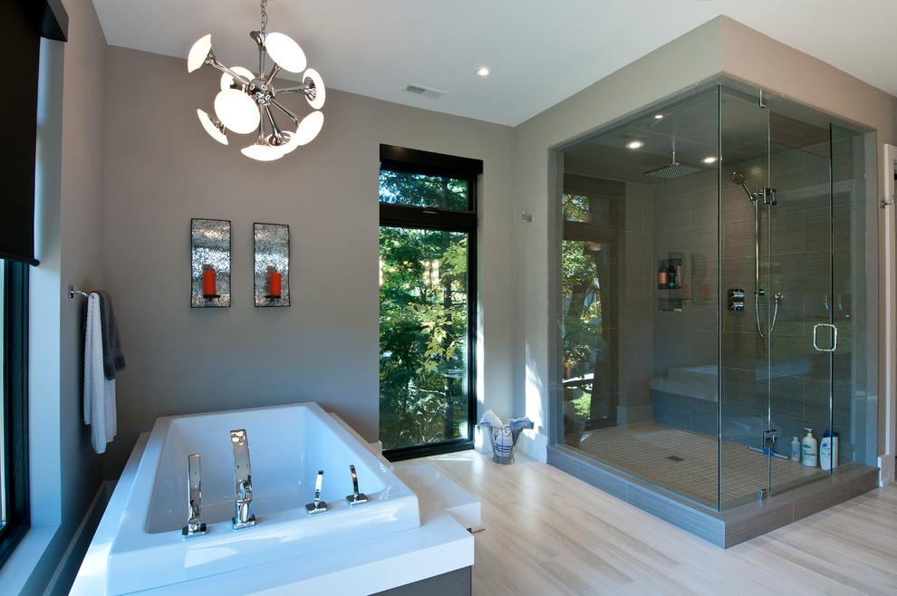 Exemple d'une salle de bain principale tendance de taille moyenne avec un placard à porte plane, des portes de placard grises, un plan de toilette en quartz modifié, une baignoire posée, un carrelage gris, des carreaux de céramique, une douche d'angle, un mur gris, un sol en carrelage de porcelaine et un lavabo encastré.