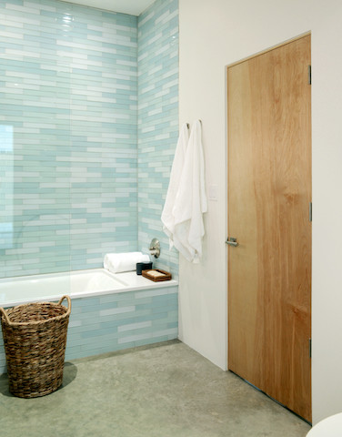 Foto på ett funkis badrum, med ett platsbyggt badkar, en dusch/badkar-kombination, blå kakel, glaskakel, vita väggar, betonggolv, grått golv och med dusch som är öppen