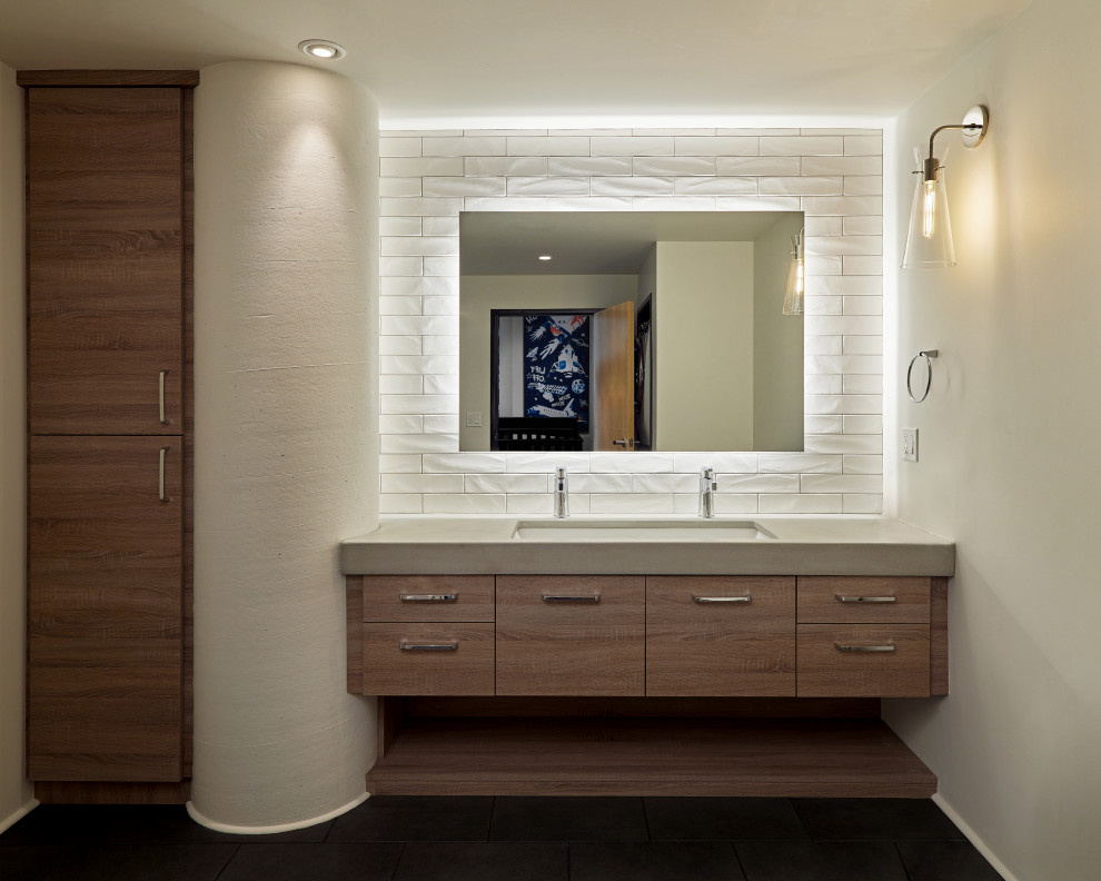 Inspiration för mellanstora moderna grått badrum med dusch, med släta luckor, skåp i ljust trä, en toalettstol med separat cisternkåpa, vit kakel, tunnelbanekakel, grå väggar, skiffergolv, ett undermonterad handfat, bänkskiva i betong och grått golv