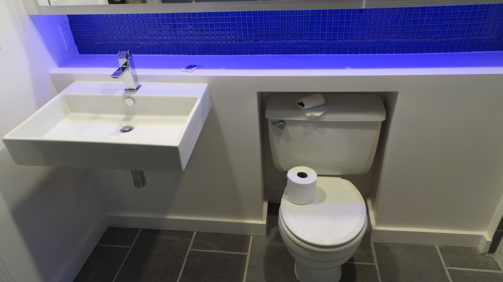 Idéer för ett mellanstort modernt badrum med dusch, med ett badkar i en alkov, en dusch/badkar-kombination, en toalettstol med separat cisternkåpa, grå kakel, porslinskakel, vita väggar, klinkergolv i porslin och ett väggmonterat handfat