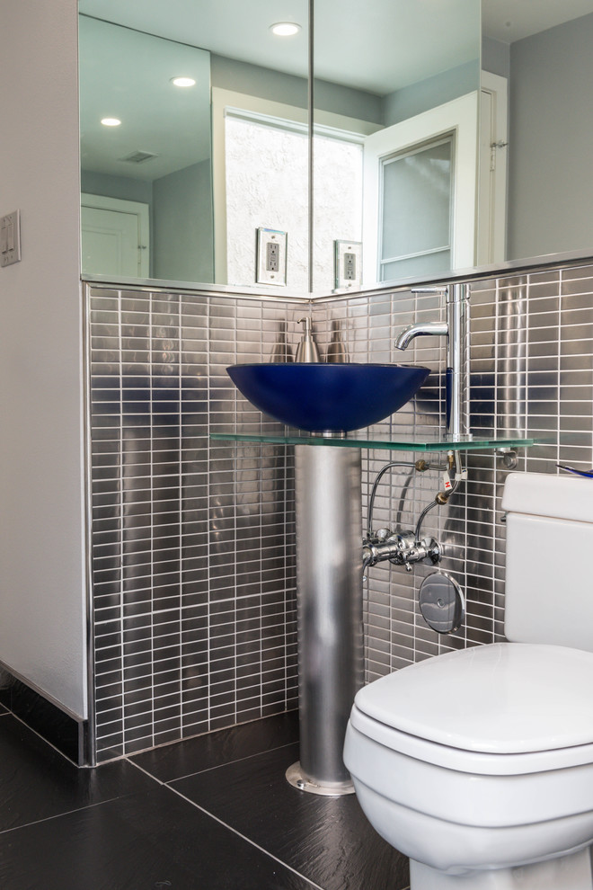 Пример оригинального дизайна: маленькая ванная комната в стиле модернизм с раздельным унитазом, серой плиткой, металлической плиткой, белыми стенами, полом из керамогранита, настольной раковиной, стеклянной столешницей и серым полом для на участке и в саду