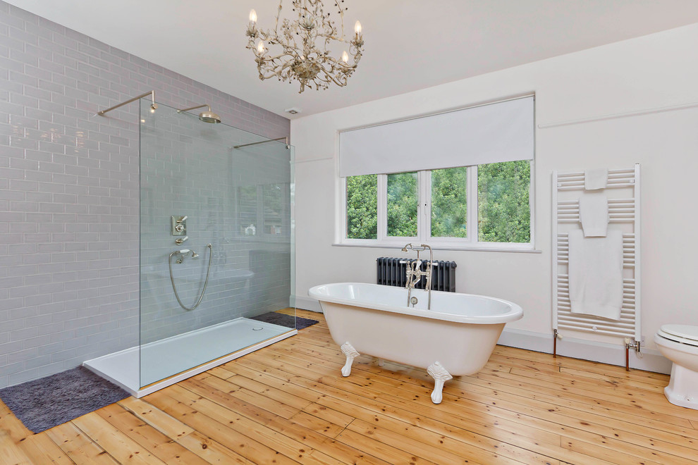 Cette image montre une salle de bain design avec une baignoire sur pieds, une douche ouverte et aucune cabine.