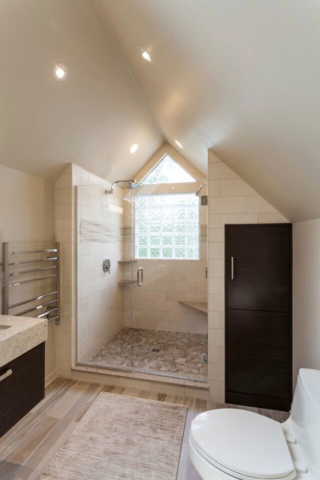 Exemple d'une salle de bain principale moderne en bois foncé avec un lavabo posé, un placard à porte plane, WC séparés, un carrelage beige, une plaque de galets, un mur beige, parquet clair et une douche d'angle.