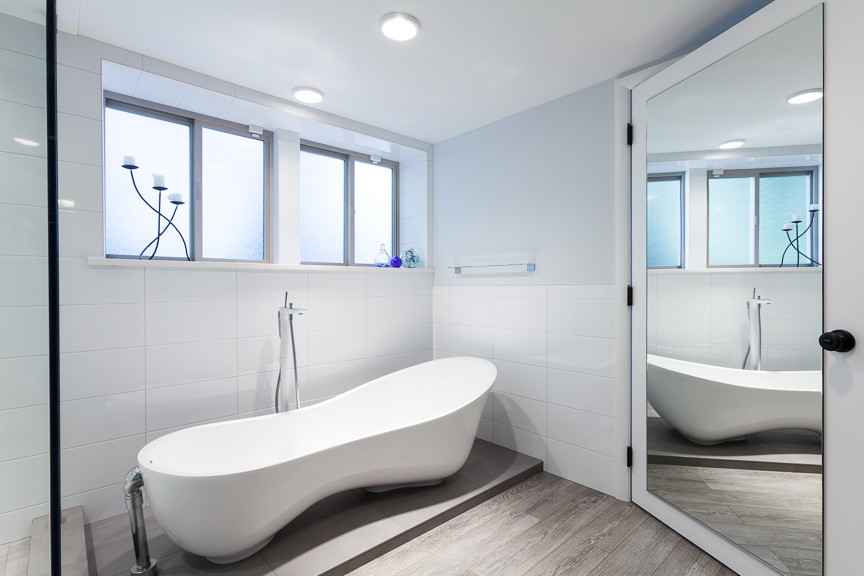 Стильный дизайн: главная ванная комната среднего размера в стиле модернизм с врезной раковиной, плоскими фасадами, белыми фасадами, столешницей из искусственного кварца, отдельно стоящей ванной, угловым душем, унитазом-моноблоком, белой плиткой, керамической плиткой, синими стенами и полом из керамической плитки - последний тренд
