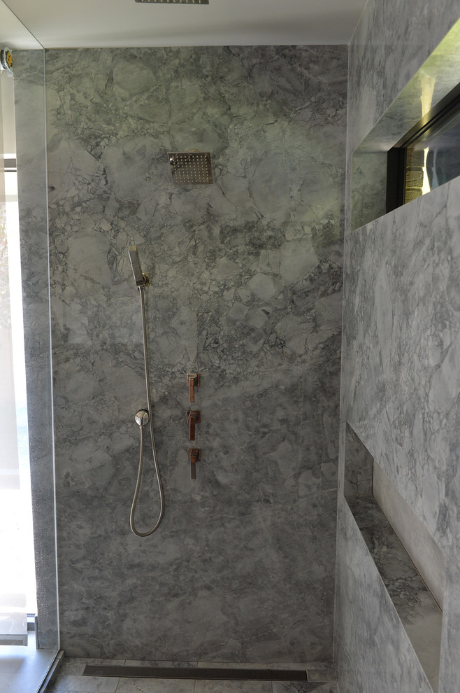 Modern inredning av ett mellanstort en-suite badrum, med släta luckor, bruna skåp, ett platsbyggt badkar, en kantlös dusch, grå kakel, stenhäll, grå väggar, cementgolv, ett undermonterad handfat och marmorbänkskiva