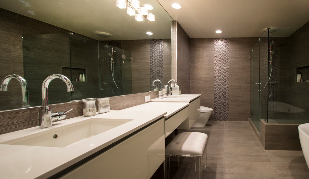 Large trendy master brown tile and porcelain tile porcelain tile bathroom photo in Los Angeles with flat-panel cabinets, white cabinets, a one-piece toilet, brown walls, an integrated sink and quartzite countertops