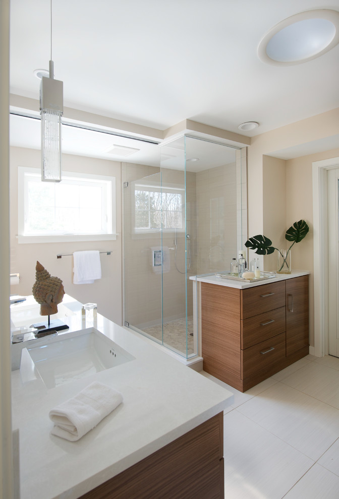 Photo of a large contemporary bathroom in Bridgeport with a submerged sink, flat-panel cabinets, medium wood cabinets, engineered stone worktops, a corner shower, beige walls and ceramic flooring.