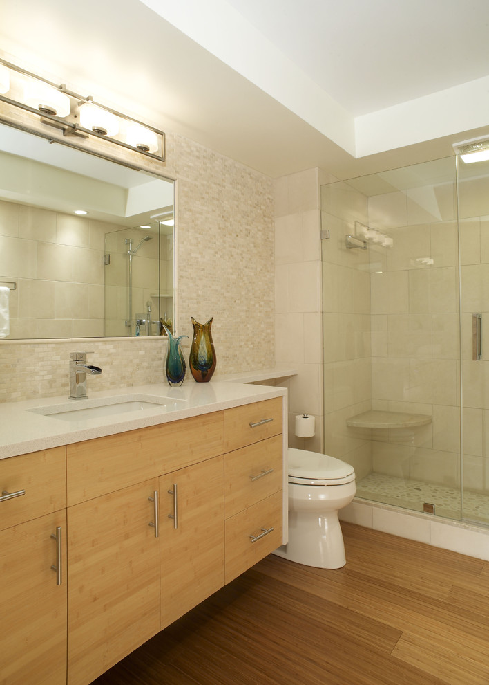 На фото: ванная комната в современном стиле с врезной раковиной, плоскими фасадами, душем в нише, бежевой плиткой, светлыми деревянными фасадами и белой столешницей