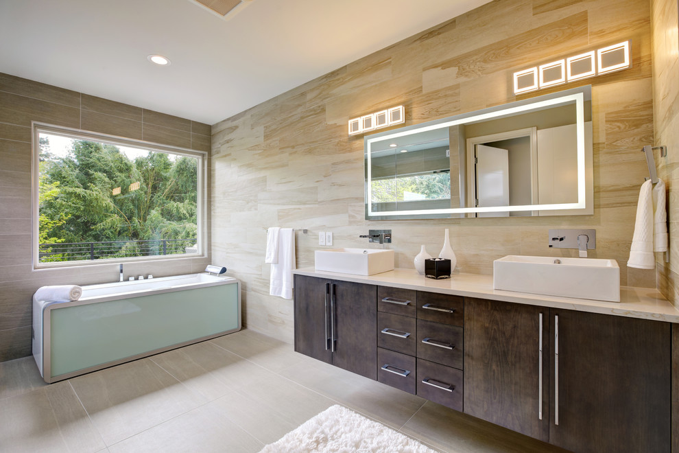 Foto på ett funkis beige en-suite badrum, med släta luckor, skåp i mörkt trä, ett fristående badkar, brun kakel, ett fristående handfat, beiget golv och dusch med gångjärnsdörr