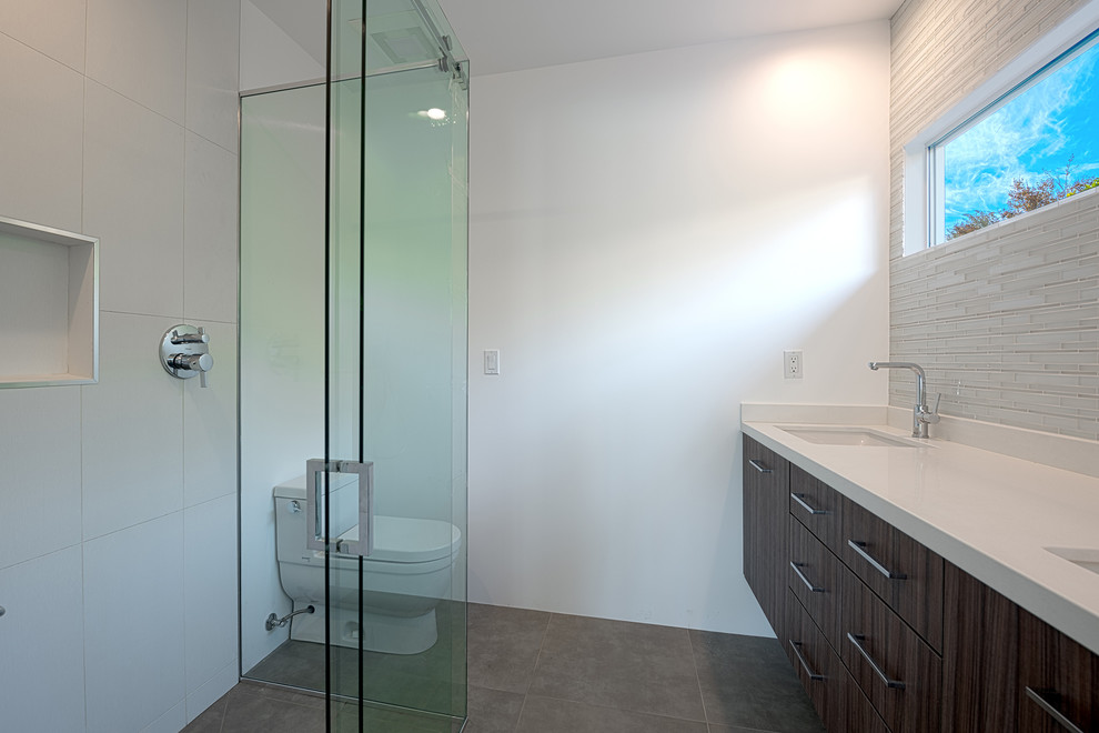 На фото: главная ванная комната среднего размера в стиле модернизм с плоскими фасадами, темными деревянными фасадами, открытым душем, белыми стенами и столешницей из искусственного кварца