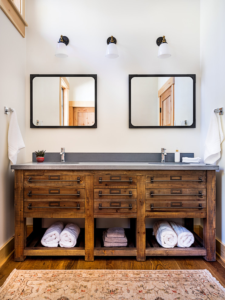 Uriges Badezimmer mit hellbraunen Holzschränken, weißer Wandfarbe, braunem Holzboden, Unterbauwaschbecken, braunem Boden, grauer Waschtischplatte und flächenbündigen Schrankfronten in Boston
