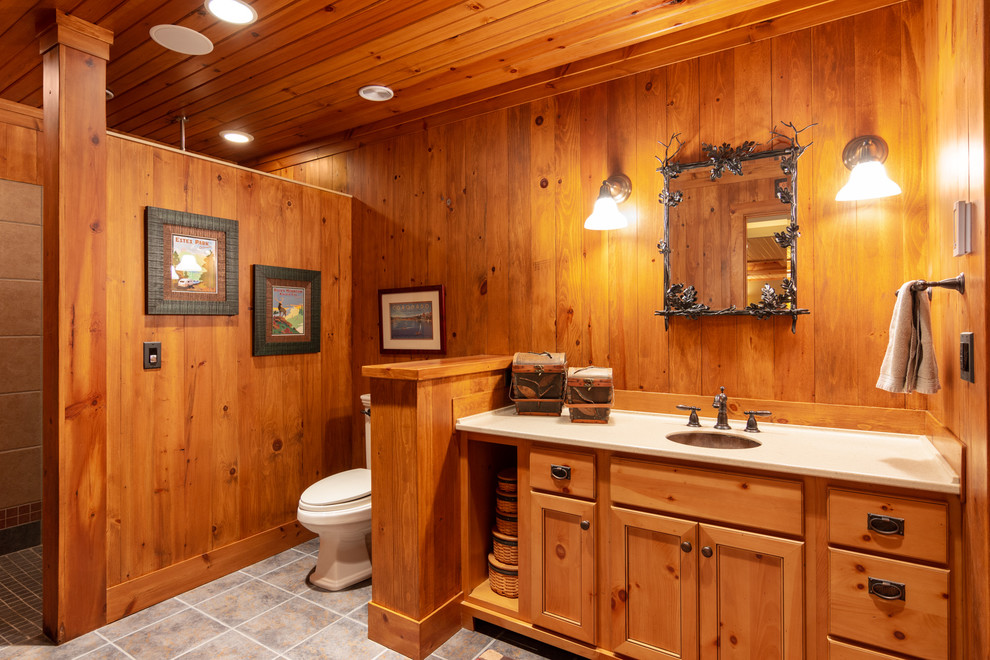 Diseño de cuarto de baño rural con armarios con paneles empotrados, puertas de armario de madera oscura, ducha a ras de suelo, lavabo bajoencimera, suelo gris, ducha abierta y encimeras blancas