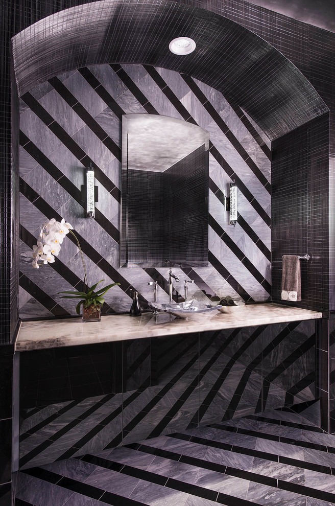 Foto di una stanza da bagno design di medie dimensioni con lavabo a bacinella, ante di vetro, ante nere, top in onice, WC sospeso, piastrelle nere, piastrelle in pietra, pareti grigie e pavimento in marmo