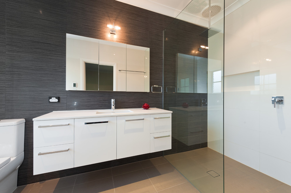 Foto de cuarto de baño principal minimalista de tamaño medio con lavabo bajoencimera, ducha abierta y sanitario de una pieza